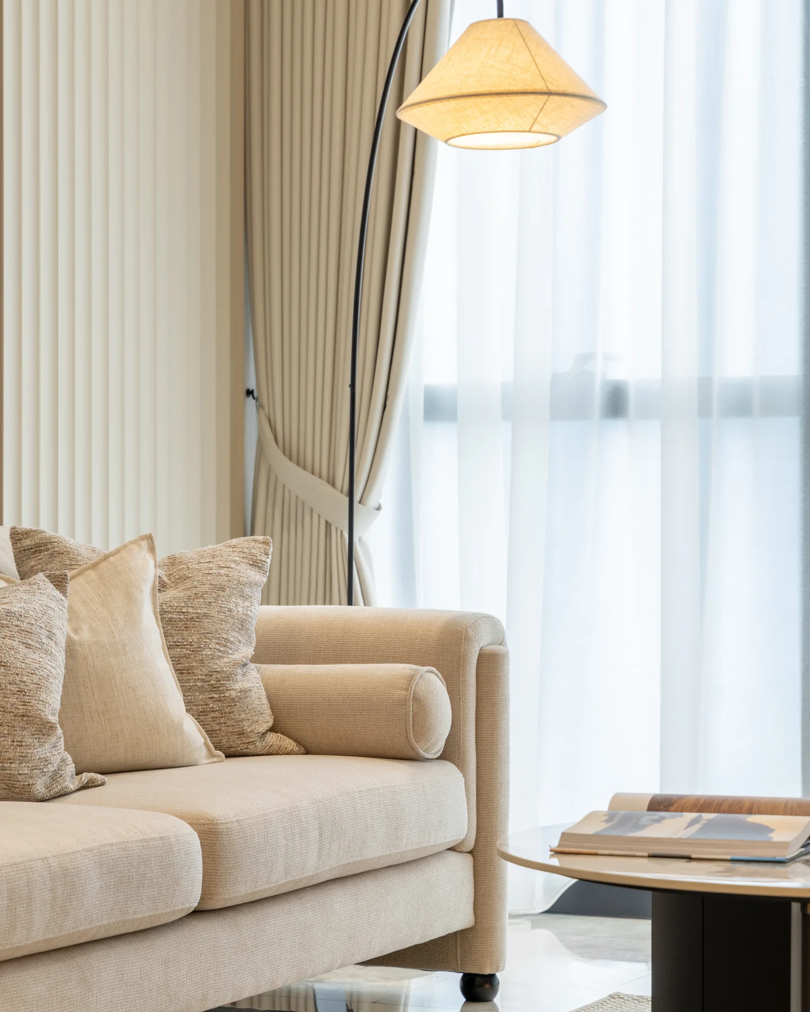 Modern living room interior in Kuala Lumpur with marble TV feature wall, walnut cabinetry and warm neutral furnishings