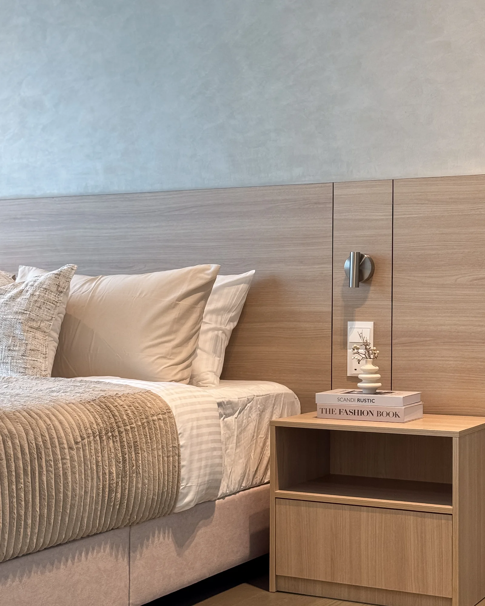 Wood bedside table with integrated wall light and decorative styling beside the master bed at Ooak Suites, Mont Kiara