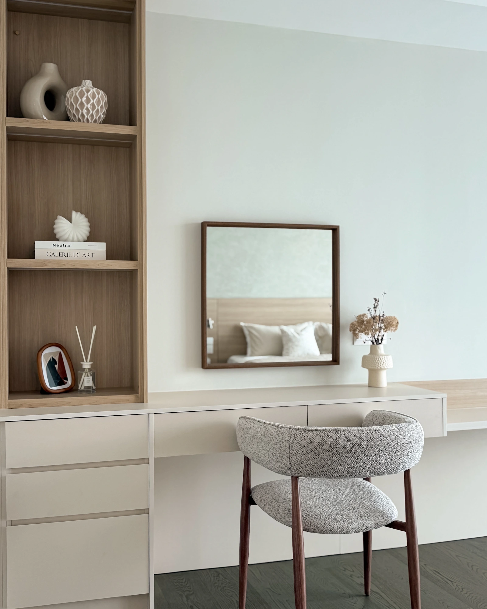 Built-in bedroom vanity with wood shelving, drawers, upholstered chair and wall mirror at Ooak Suites, Mont Kiara
