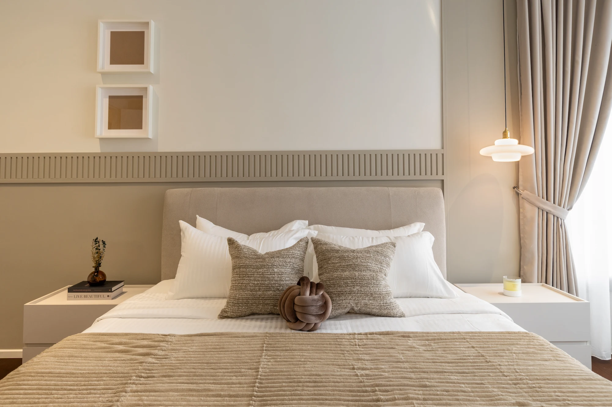 Modern master bedroom interior design in Allevia Mont Kiara condominium, Kuala Lumpur, featuring a custom upholstered headboard, built-in bedside tables, neutral textiles and warm beige tones.