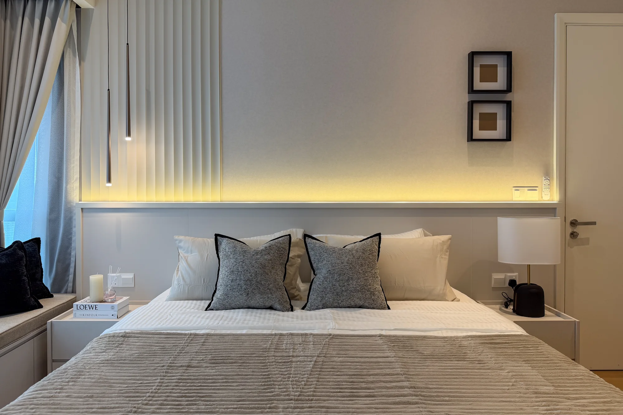 Modern master bedroom interior design at TRX Residences, Kuala Lumpur, featuring a custom upholstered bed, integrated bedside tables, soft neutral tones and warm ambient lighting.