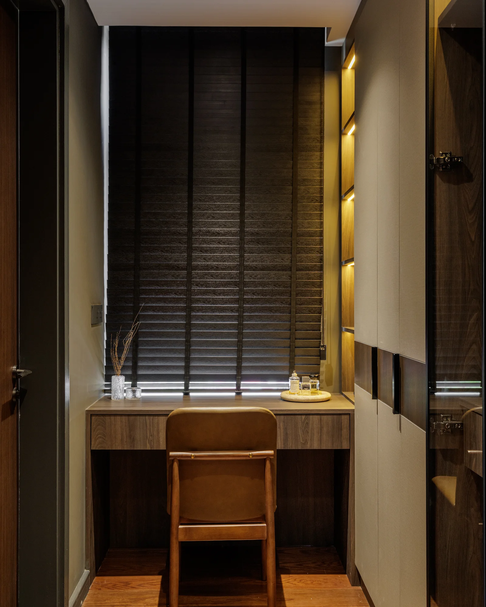 The Radius compact study nook with a built-in wood desk, leather chair, concealed storage, and warm integrated lighting.
