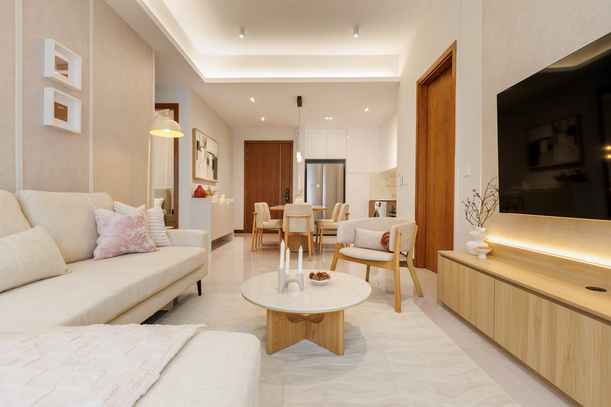 Bright living room with cream sectional sofa, timber cabinetry, marble coffee table and large windows